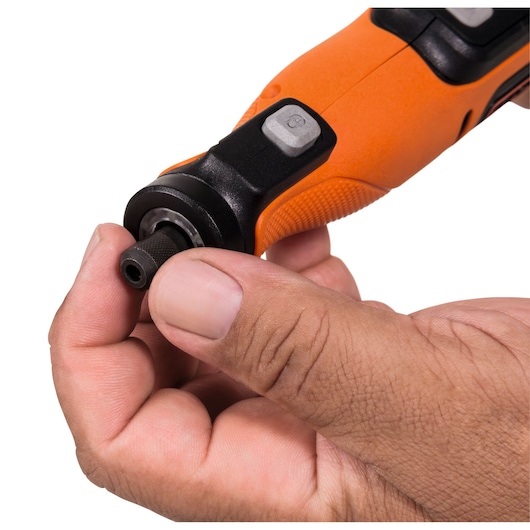 Close-up of a person holding and adjusting the tip of an orange and black rotary tool.
