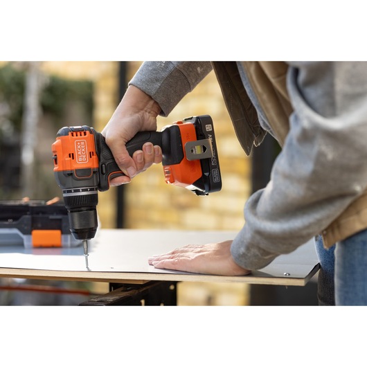 BLACK+DECKER BLD782N cordless drill in use driving screw into wood, close-up side angle.