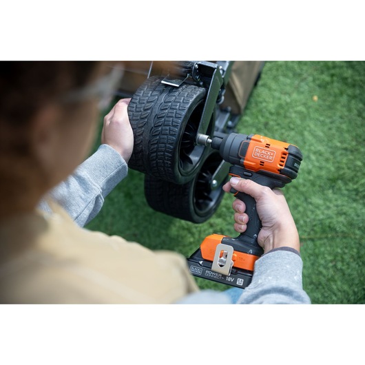 Photo of BLACKDECKER BLIM78E1K cordless impact driver being used to tighten wheel bolts outdoors.