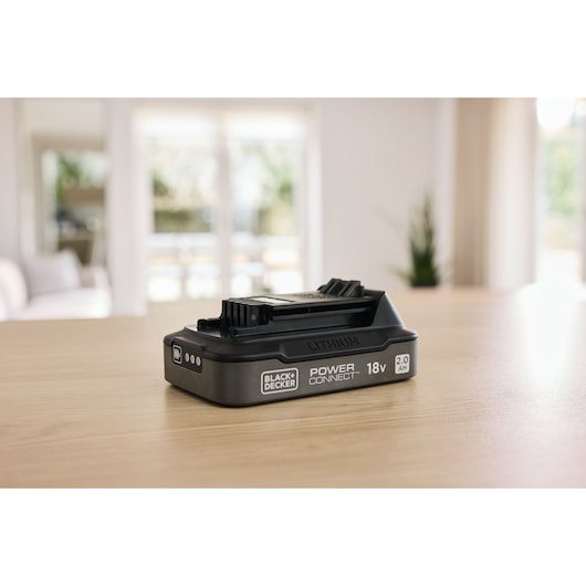 The BLACK+DECKER® POWERCONNECT™ 18V 2.0 Ah State of Charge Li-ion Battery on a tabletop.