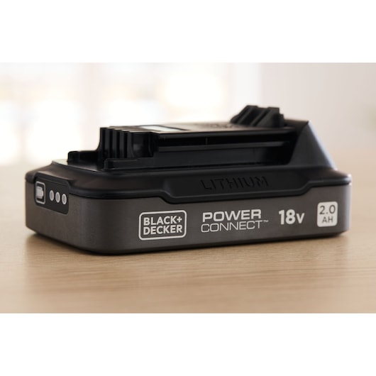 Close-up of the BLACK+DECKER® POWERCONNECT™ 18V 2.0 Ah State of Charge Li-ion Battery on a tabletop.