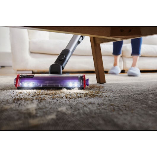 BLACK+DECKER SUMMITSERIES cordless stick vacuum vacuuming debris under coffee table