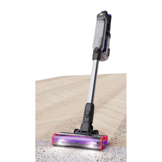 The vacuum in action, moving from a hardwood floor to carpet - BLACK+DECKER SUMMITSERIES select Pet cordless stick vacuum.