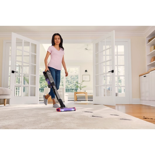 BLACK+DECKER SUMMITSERIES cordless stick vacuum vacuuming dirt off rug