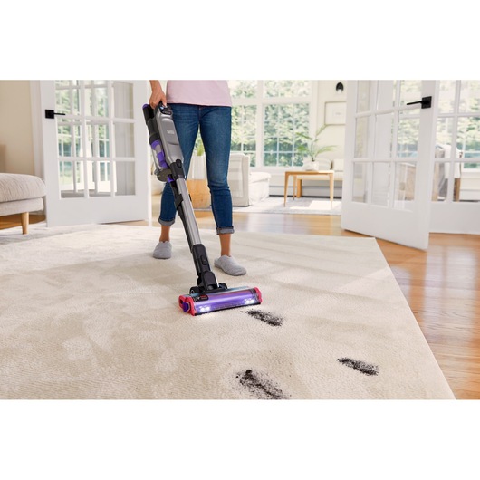 BLACK+DECKER SUMMITSERIES cordless stick vacuum vacuuming dirt off rug, close up