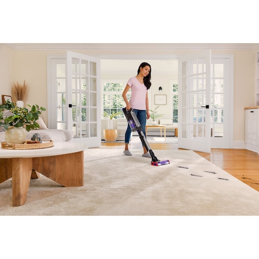 BLACK+DECKER SUMMITSERIES cordless stick vacuum vacuuming dirt off rug