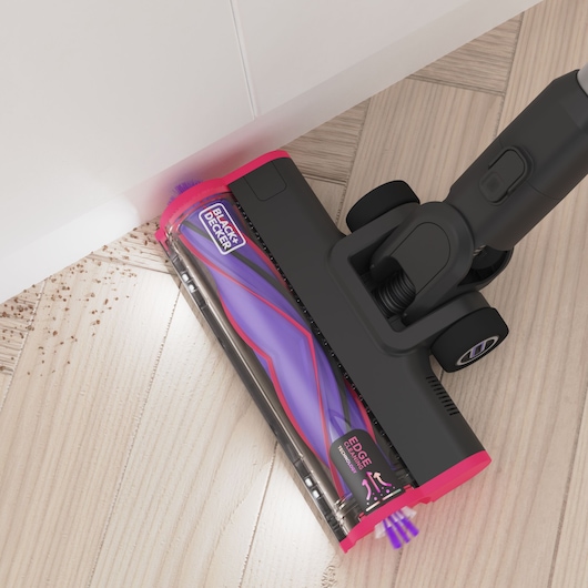 Overhead view of the edge-to-edge cleaning capturing debris alongside a skirting board - BLACK+DECKER SUMMITSERIES select Pet cordless stick vacuum.