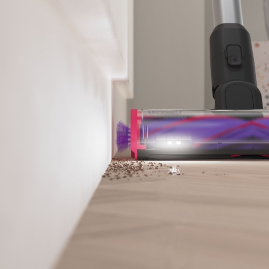Front view of the edge-to-edge cleaning capturing debris alongside a skirting board - BLACK+DECKER SUMMITSERIES select Pet cordless stick vacuum