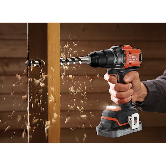 A wooden column being drilled into with an auger drill bit using the BLACK+DECKER® 18V POWERCONNECT™ Brushless Hammer Drill.